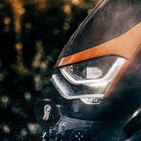 Valtra S-Series tractor equipped with TYRI Special designed LED drive lights and work lights, operating in a rural farmland landscape under daylight.