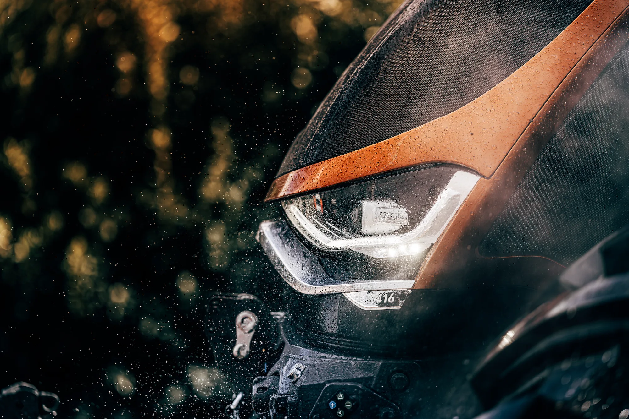 Valtra S-Series tractor equipped with TYRI Special designed LED drive lights and work lights, operating in a rural farmland landscape under daylight.