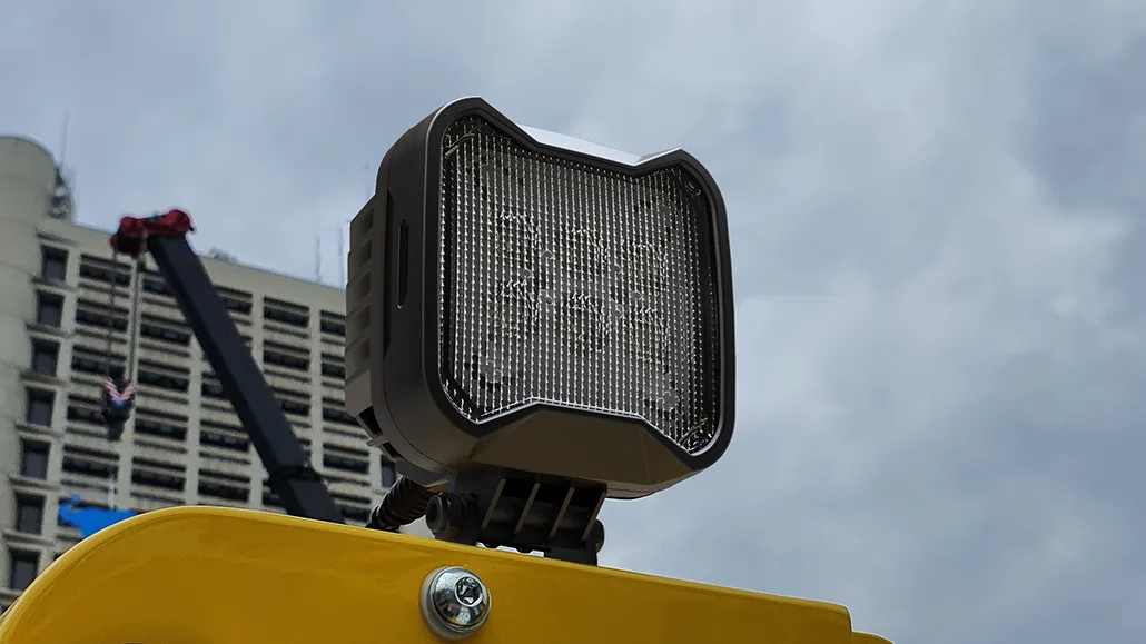 Il faro da lavoro TYRI BASEline S2 LED, montato sul tetto di un veicolo industriale giallo, fornisce un'illuminazione duratura per le operazioni di costruzione e fuori strada.