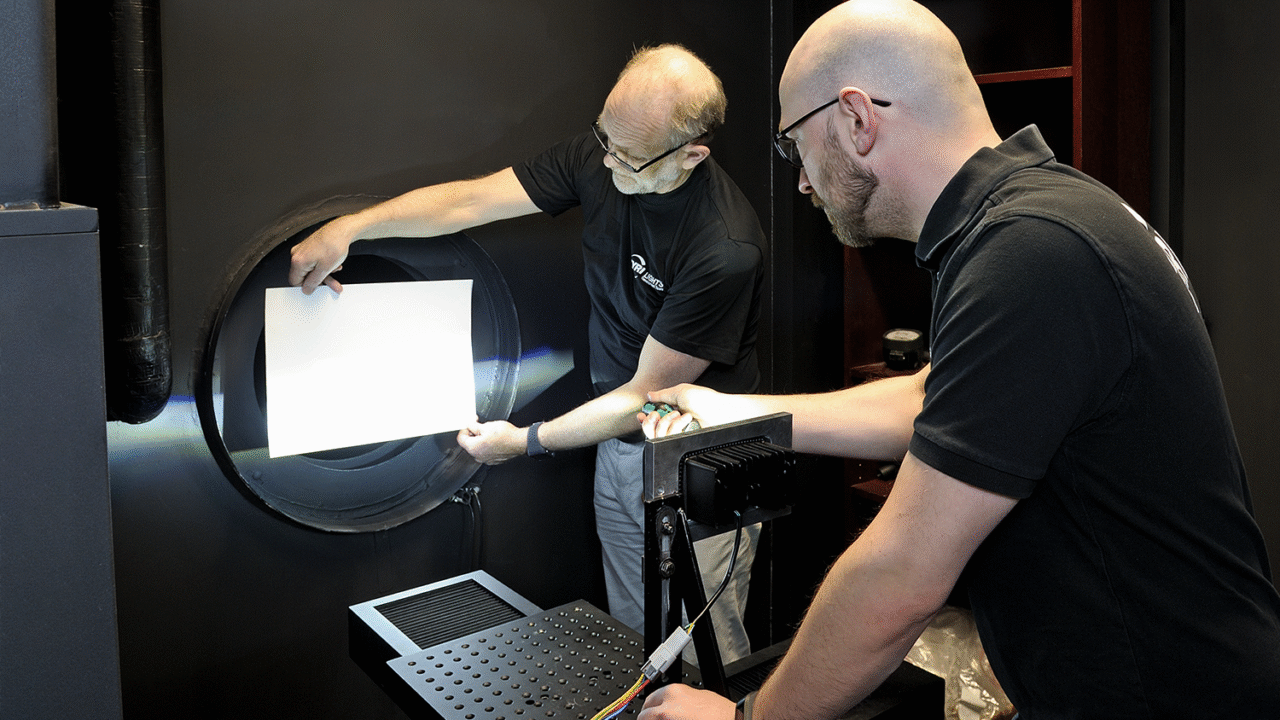 Engineers testing LED work light performance using a goniophotometer in the TYRI light lab to measure illumination patterns and ensure optical quality and accuracy