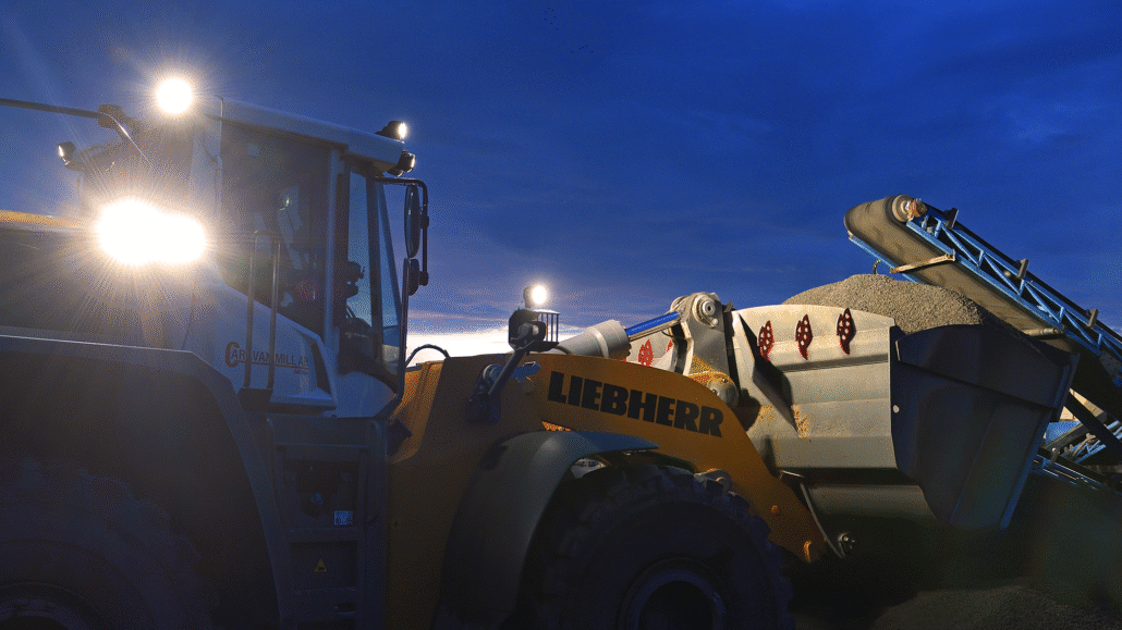 Liebherr wheel loader operating in a quarry at dusk, equipped with TYRI 1010 Hi-CRI LED work lights providing bright, natural illumination for enhanced visibility and safety.